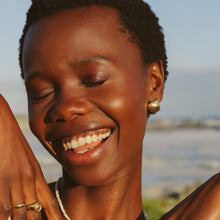 Load image into Gallery viewer, Happy woman wearing gold earrings on the beach